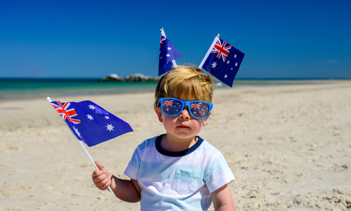 child on beach with australian flags