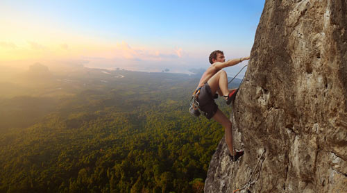 man free climbing a mountain rock face