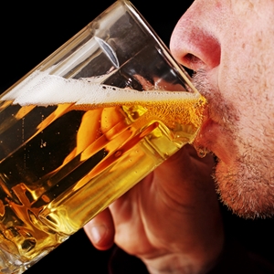 man drinking from a beer glass