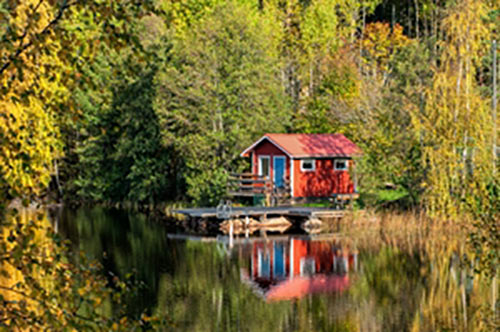 red cabin on a lakeside in the forest